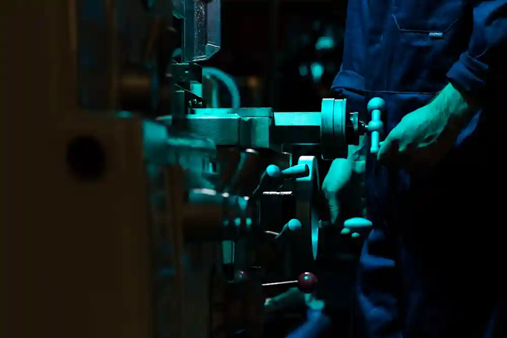 Engineer adjusting industrial lifting machinery in workshop for CAD engineering & layout development